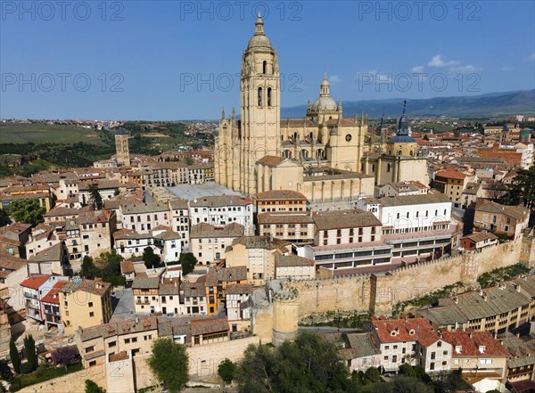 A city view with an imposing cathedral in the centre, surrounded by historic buildings on a hill,