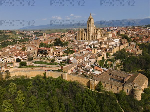 View of a historic city with an imposing church in the centre and many buildings on a hill, aerial