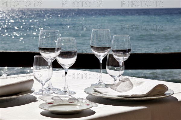 Diano Marina, 13.10.2009, Table set with wine glasses and napkins in a restaurant by the sea,