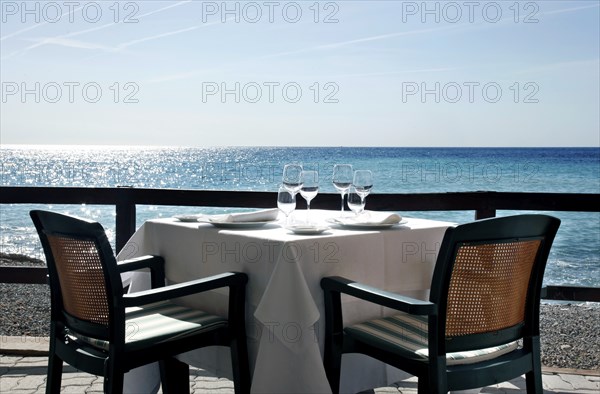 Diano Marina, 13.10.2009, Table set with wine glasses and napkins in a restaurant by the sea,