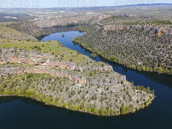Expansive view of a river winding through deep gorges and a mountainous landscape, aerial view,