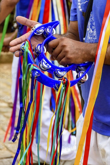 Tambourine player with his instrument decorated with colorful ribbons during a performance at a