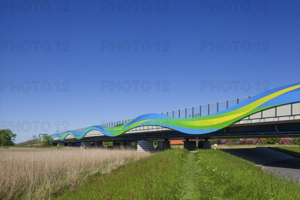 Colourfully painted motorway bridge with noise barrier over the river Este, Buxtehude, Altes Land,