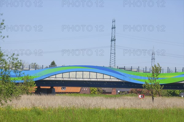 Colourfully painted motorway bridge with noise barrier over the river Este, Buxtehude, Altes Land,