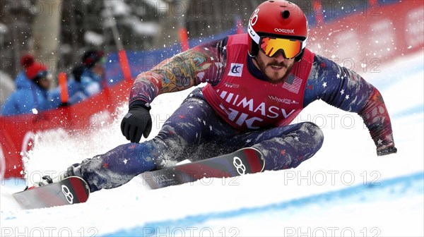 Snowboarder making a sharp turn during a race, with a focused expression and dynamic winter sport