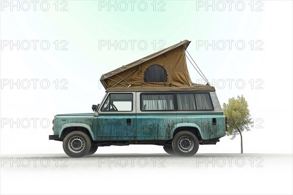 Vintage green camper van with a tent roof in a quiet, open area next to a single tree, AI generated