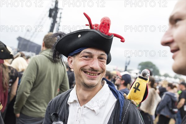 Festival visitor dressed as a pirate with parrot and octopus at the Wacken Open Air in Wacken. The