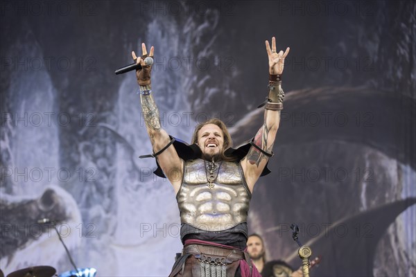 Captain Feuerschwanz, singer of the band Feuerschwanz, shows the metal salute at the Wacken Open