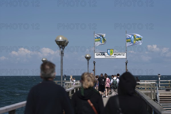 Holidaymakers on the pier, flags in the background, Graal-Müritz, Mecklenburg-Vorpommern, Germany,