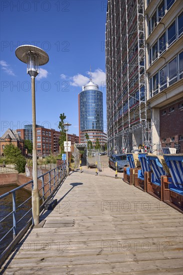 Wooden jetty with lantern and beach chairs, Hanseatic Trade Centre with scaffolding and Columbus