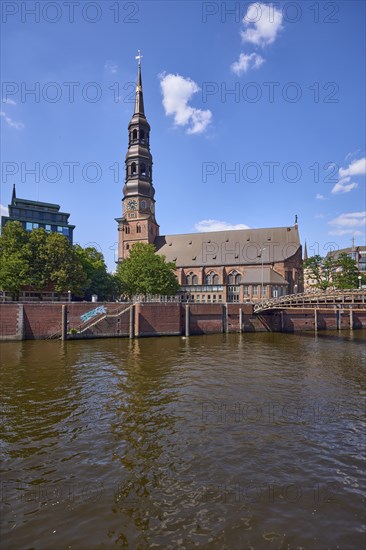 Customs canal with main church St. Katharinen against blue sky with cumulus clouds, Speicherstadt,