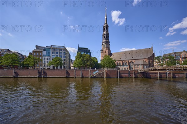 Customs canal with main church St. Katharinen against blue sky with cumulus clouds, Speicherstadt,
