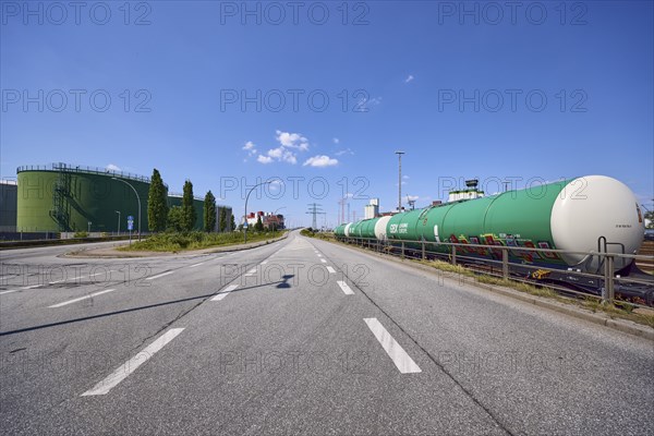 Road with oil tanks and a railway line with tank wagons in the port of Hamburg, Free and Hanseatic