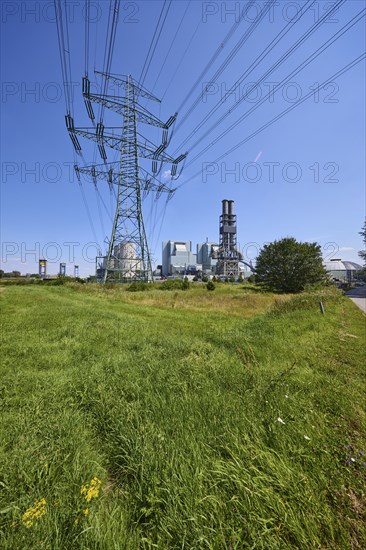 Moorburg coal-fired power station with high-voltage pylon against a cloudless blue sky in the