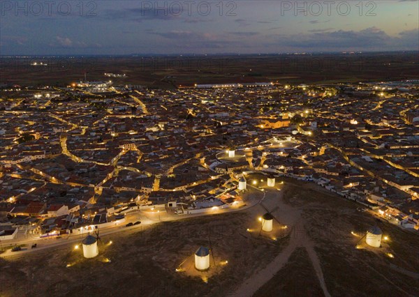 Night view of a village with illuminated windmills. The streets of the village are illuminated by
