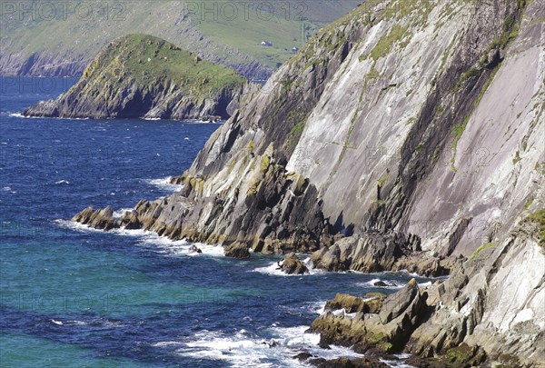 Steep cliffs with grassy areas above the rushing sea and rocky shores, Tourism, Slea Head Drive,