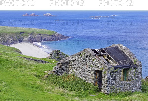 Stone ruins with grass cover on the coast with islands in the background, Blasket Islands, Dunmore