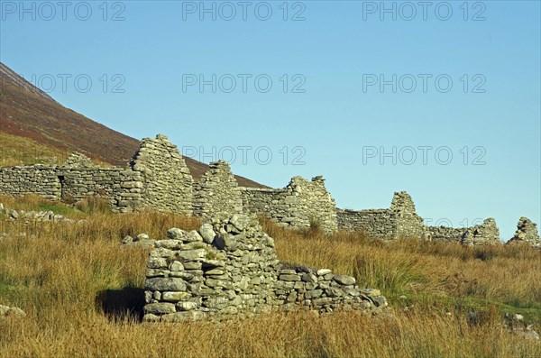 Stone ruins in a meadow under a clear sky, Achill Island, County Mayo, Ireland, Europe