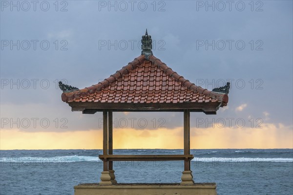 Fantastic sunrise on the beach with small temples and built as breakwaters. View of the sea as far