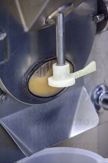 Close-up of a machine dispensing ice cream mix during production
