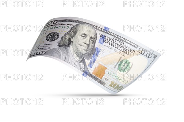 One hundred dollar bill floating down to surface with drop shadow isolated on a white background
