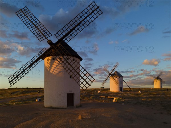 Several windmills at sunset in an open landscape under a cloudy sky, windmills, Campo de Criptana,