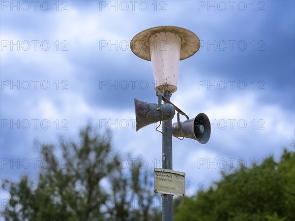 Weathered street lamp with loudspeakers next to a campsite on Lake Jersleben, Jersleben,
