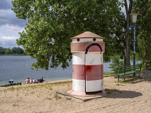 Old round red-white-ringed changing room from GDR times in the shape of a lighthouse on the shore