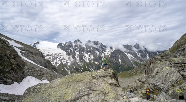 Mountaineer in a rocky saddle, Lapenscharte with view of mountain peaks and glacier into the valley