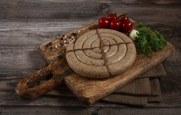 Raw spiral sausages, on a wooden board, top view, no people