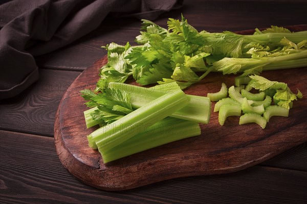 Fresh bunch of celery, top view, no people, on a dark background