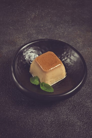 Cream caramel pudding, with caramel sauce, dessert, breakfast, on a black plate, mint, no people