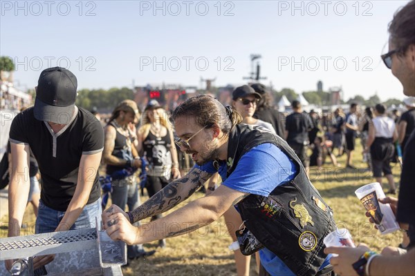 Festival visitors refresh themselves at the Wacken Open Air in Wacken. The traditional metal