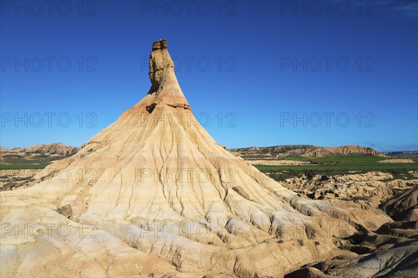 Striking rock formations rise up in an arid landscape under a deep blue sky, Castildetierra,