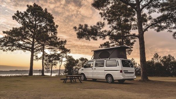 White camper van parked by trees near lake at sunset creating a tranquil outdoor camping scene, AI