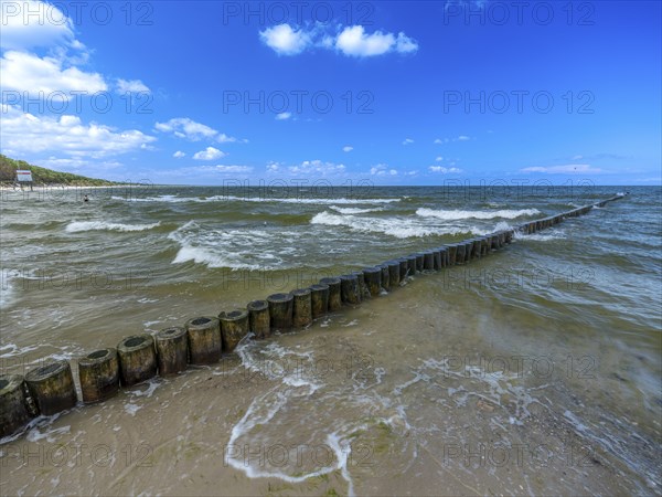 Sandy beach beach with wooden groyne in the Baltic Sea on the island of Usedom, clouds in the blue
