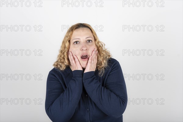 Plus size woman with a look of disgust and surprise grabs her head and looks up