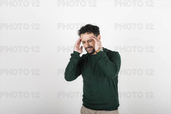 Stressed and tired man touches his head because of a headache