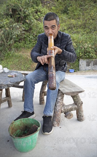Vietnamese man smoking a thick bamboo pipe, Ha Giang province, Vietnam, Asia