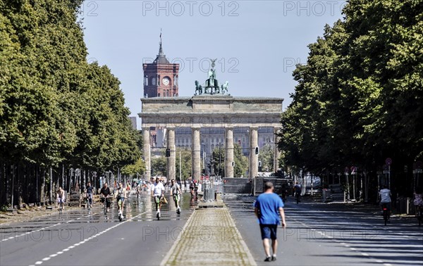 Pedestrians, cyclists and e-scooters on the road on the Strasse des 17 Juni at the Brandenburg Tor,