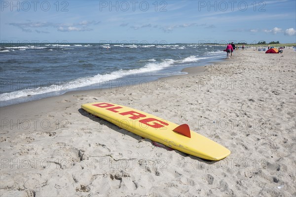 A rescue board of the German Life Saving Association DLRG lies on the sandy beach of the Baltic