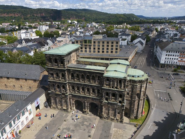 Historical architecture of the Porta Nigra with city view and green roofs in Germany, aerial view,
