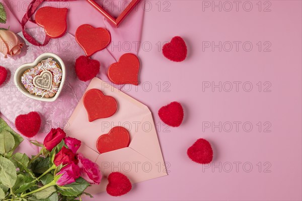 Heart-shaped cupcake, red hearts and roses around an envelope, Valentine's Day, pink background