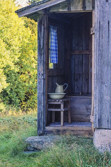 Idyllic old outhouse with a jug and sink in the country at summer, Sweden, Europe