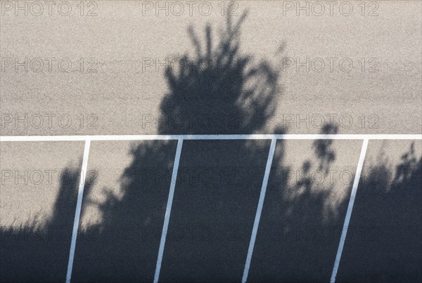 Drone shot, empty car park with shadows cast by trees, from above, structure, road traffic,