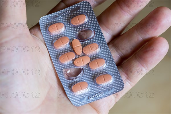 Hand holding a blister pack with tablets