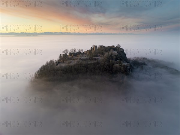 Aerial view of the Hegau volcano Hohentwiel with the upper fortress ruins in front of sunrise,