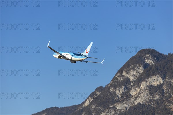 TUI airline aircraft taking off at Innsbruck Kranebitten Airport, Boeing 737-800. Snow-covered