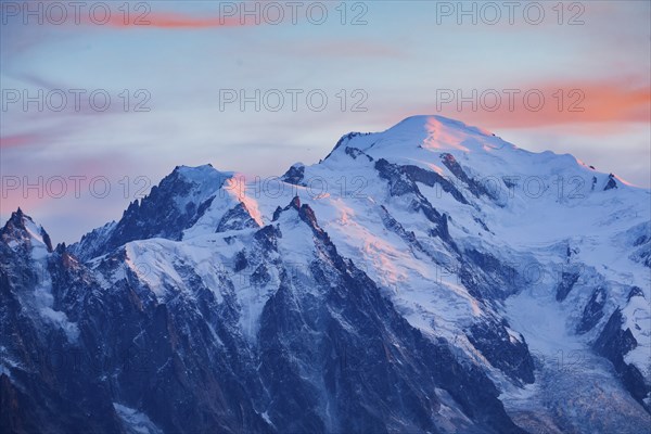 Red-coloured clouds over the summit of Mont Blanc with Aiguille du Midi in the foreground, Savoie,