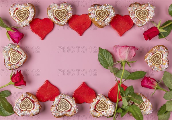 Frame made of heart-shaped cupcakes, red hearts and roses, Valentine's Day, pink background